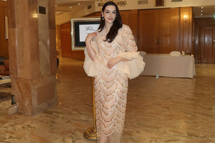 Elegant woman in a beaded formal dress at an indoor wedding venue