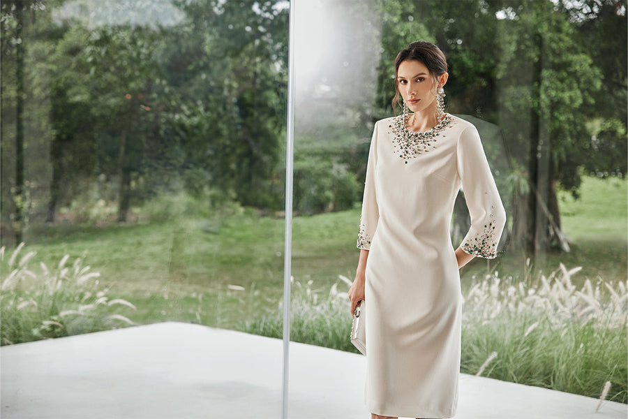 woman wearing elegant white dress with embellishments in modern garden setting