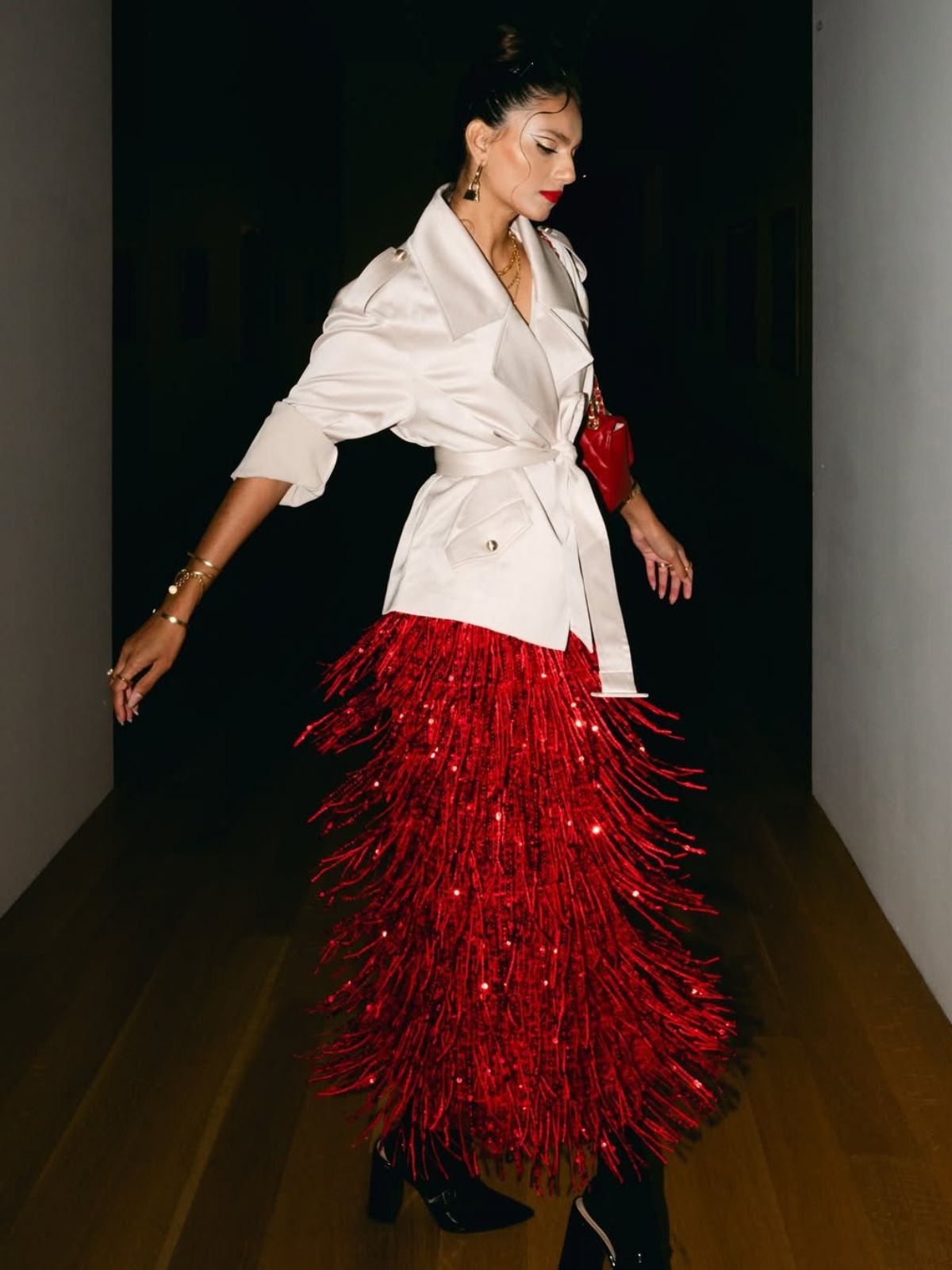 Elegant woman wearing a white blazer and red sequin fringe skirt outfit