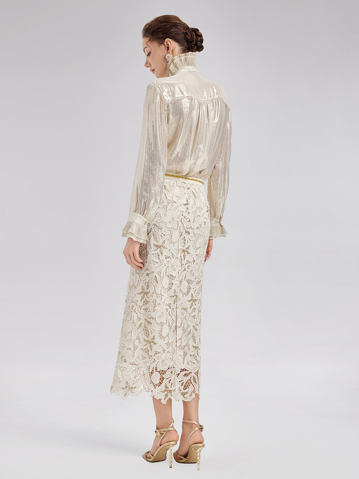 Elegant woman in a white embroidered lace skirt and sheer textured blouse with refined details