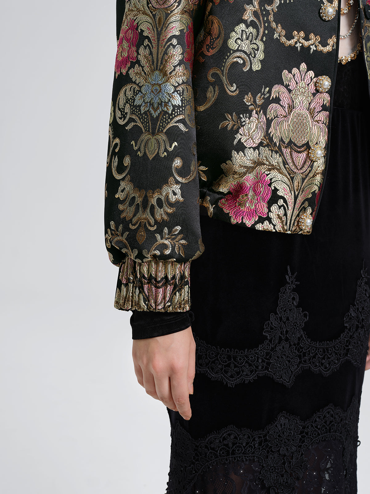 Detailed view of a black floral embroidered jacket with decorative sleeves and elegant lace skirt