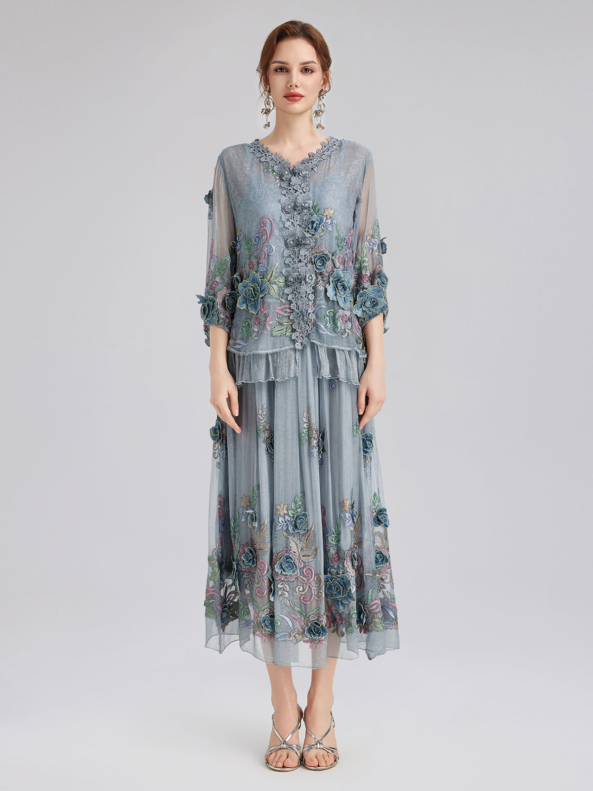 Elegant woman in a light blue floral embroidered jacket and layered midi skirt outfit