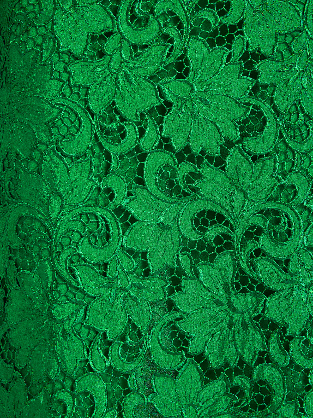 Detailed close-up of emerald green lace fabric featuring delicate floral embroidery and openwork texture