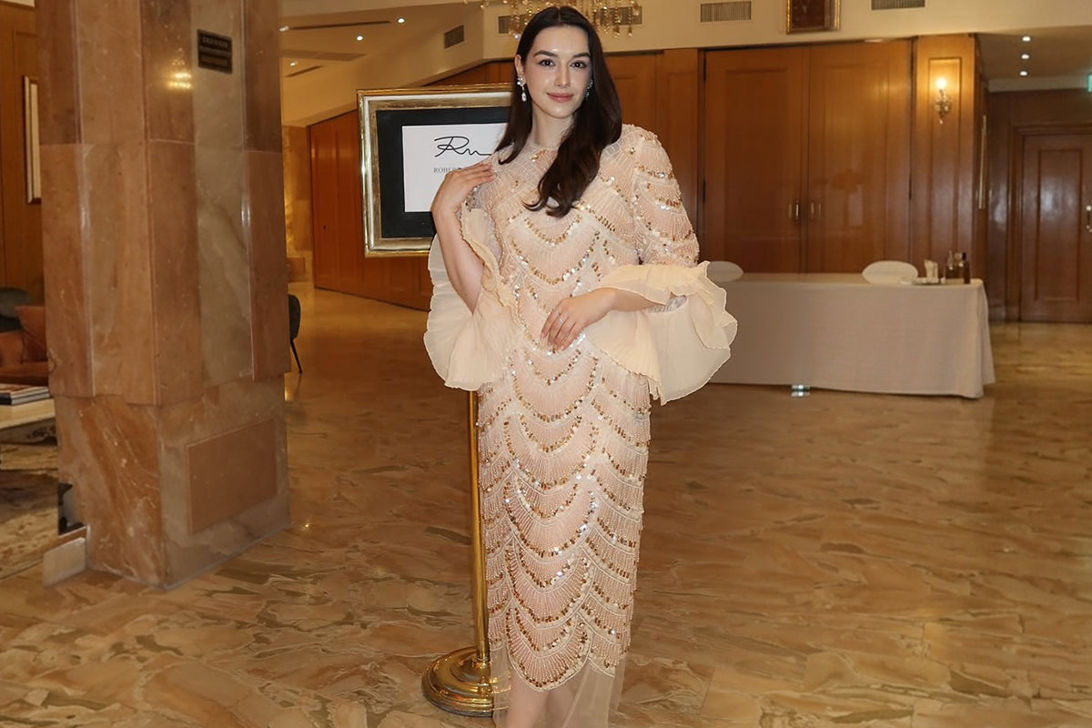 Elegant woman in a beaded formal dress at an indoor wedding venue