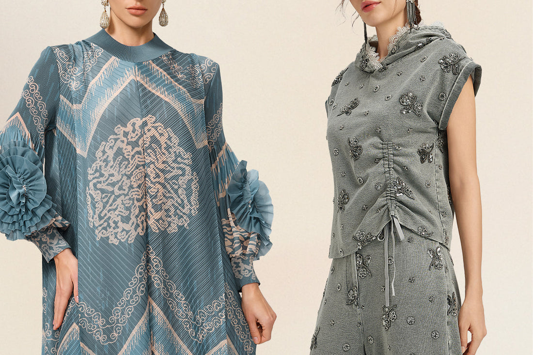 Two women modeling elegant modest fashion, featuring a blue pleated patterned dress and a gray embellished hooded top with matching pants.