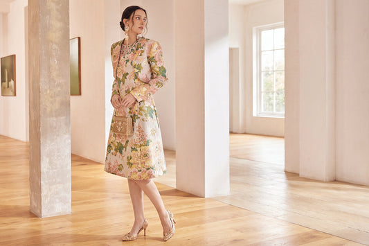 Woman wearing a long-sleeve floral A-line wedding guest dress with an elegant midi skirt
