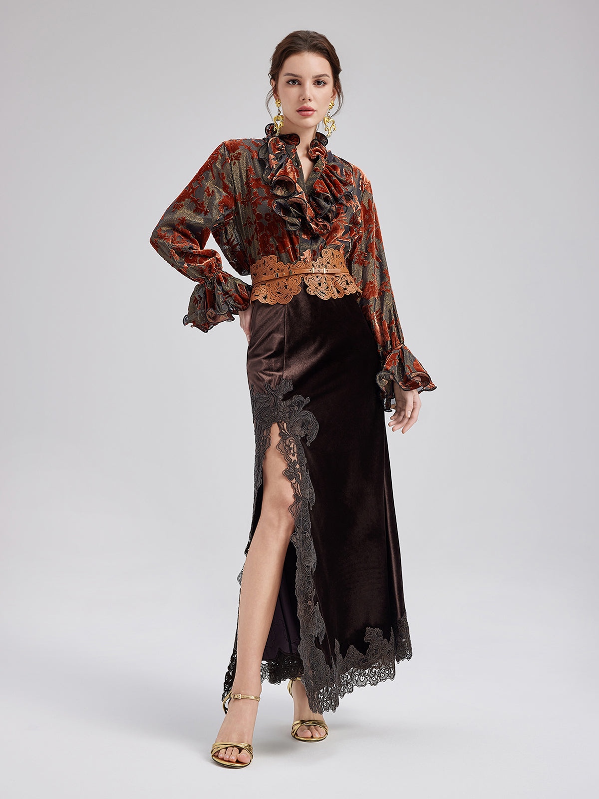 Elegant woman in a red patterned ruffle blouse with lace details and a black embroidered midi skirt