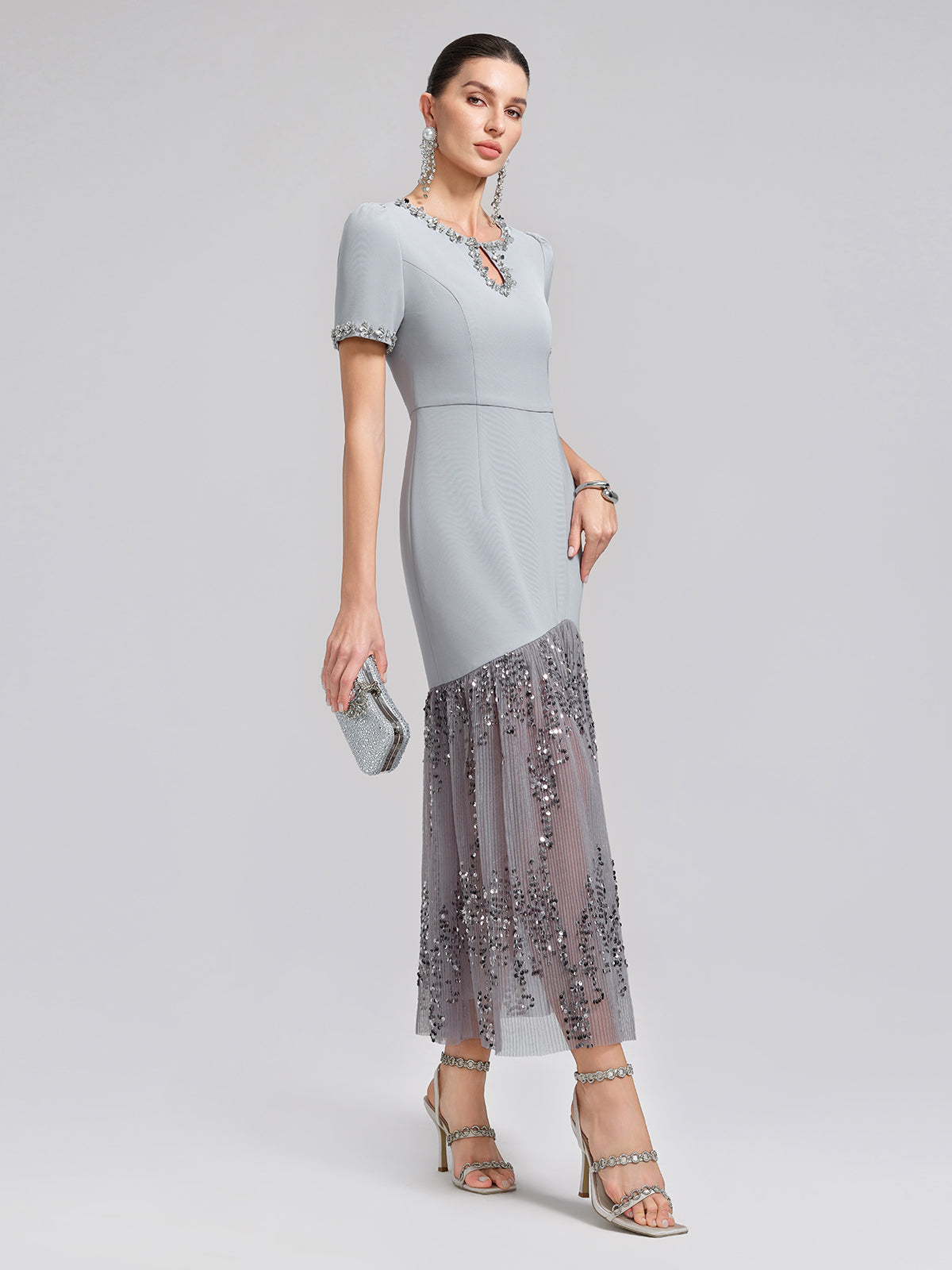 Elegant woman in a light gray fitted midi dress with sparkling sequin skirt detail and short sleeves