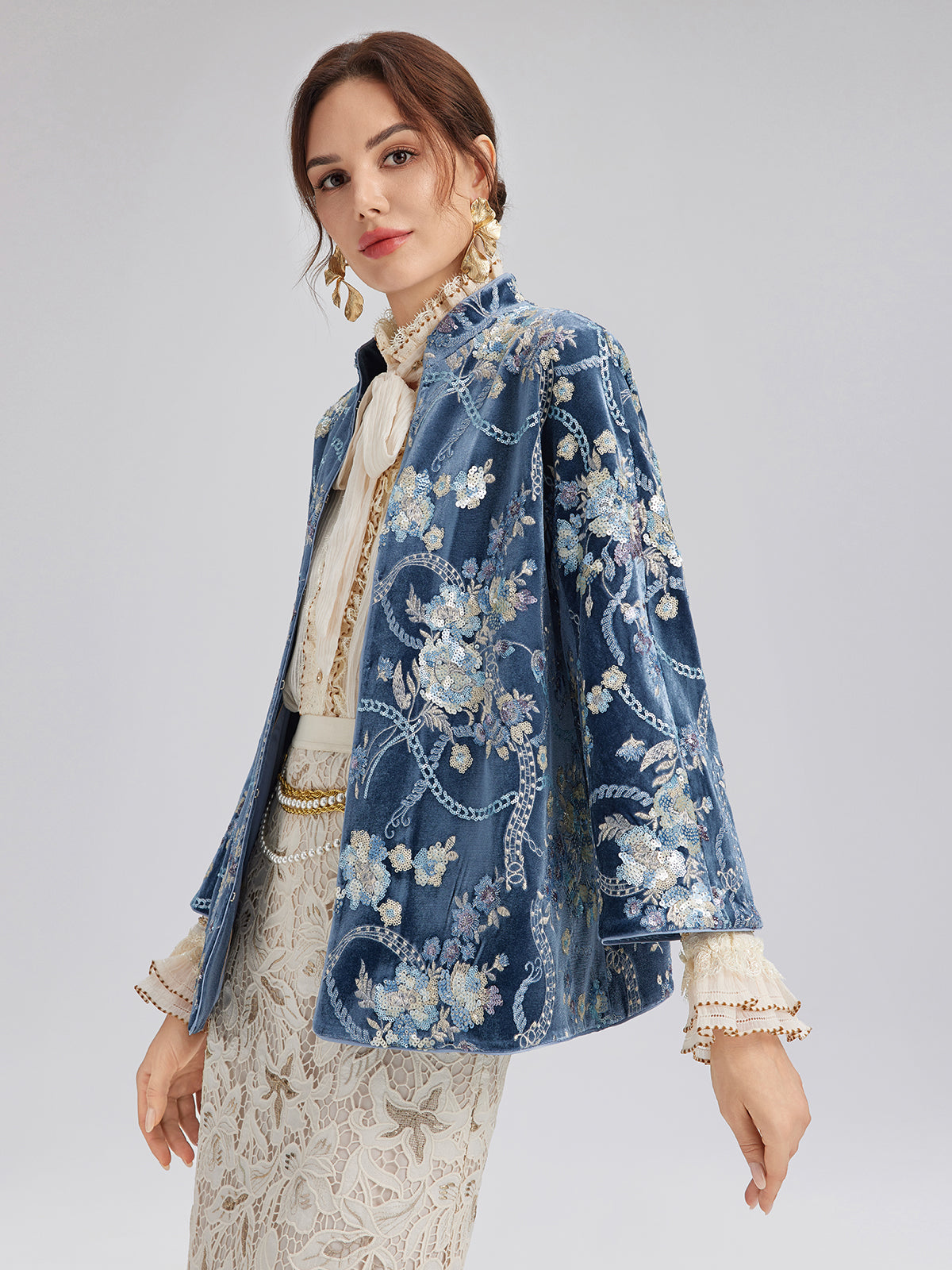 Elegant blue floral embroidered jacket featuring intricate patterns paired with a white lace dress